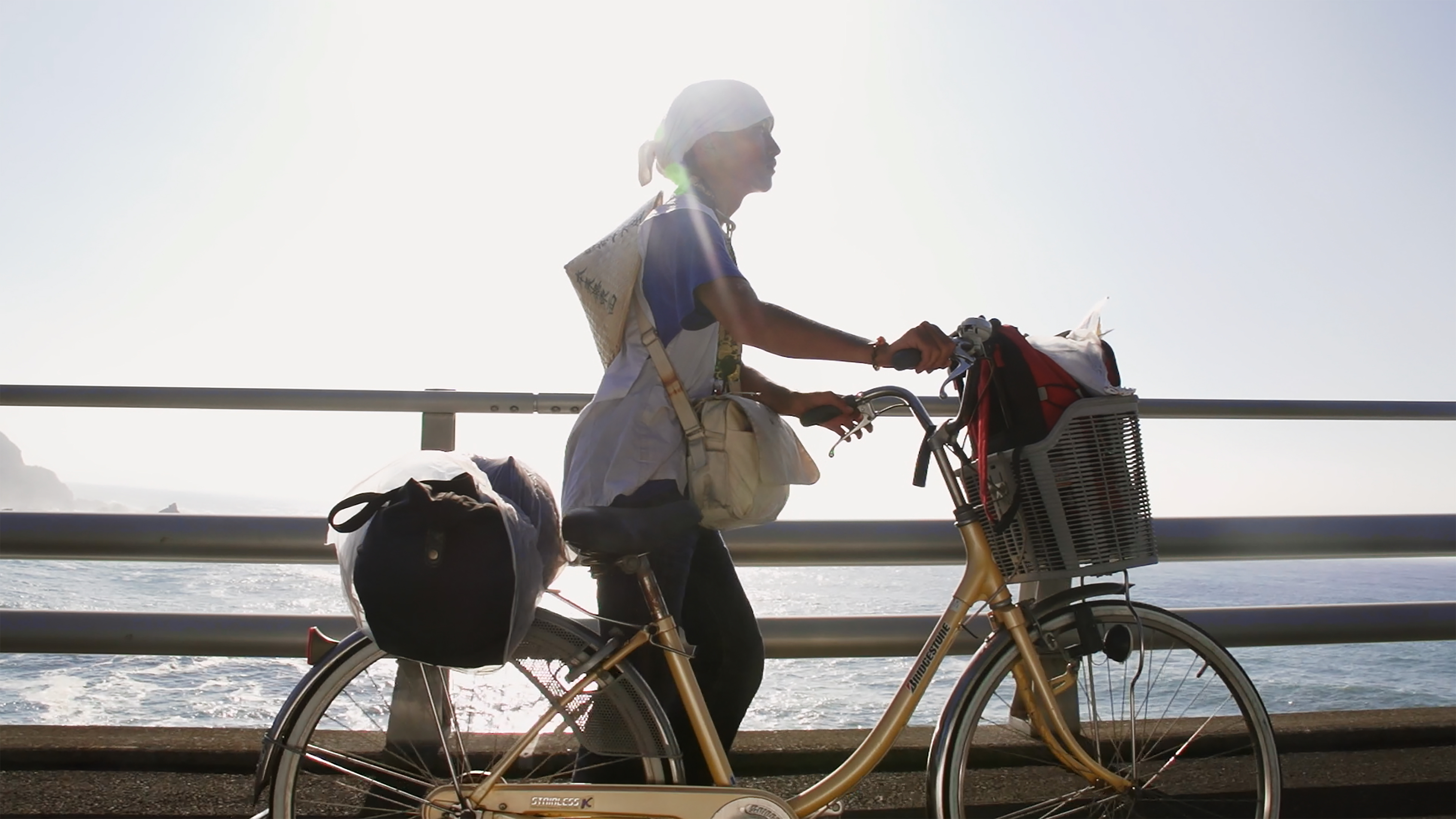 Takaoka walks while pushing his bike