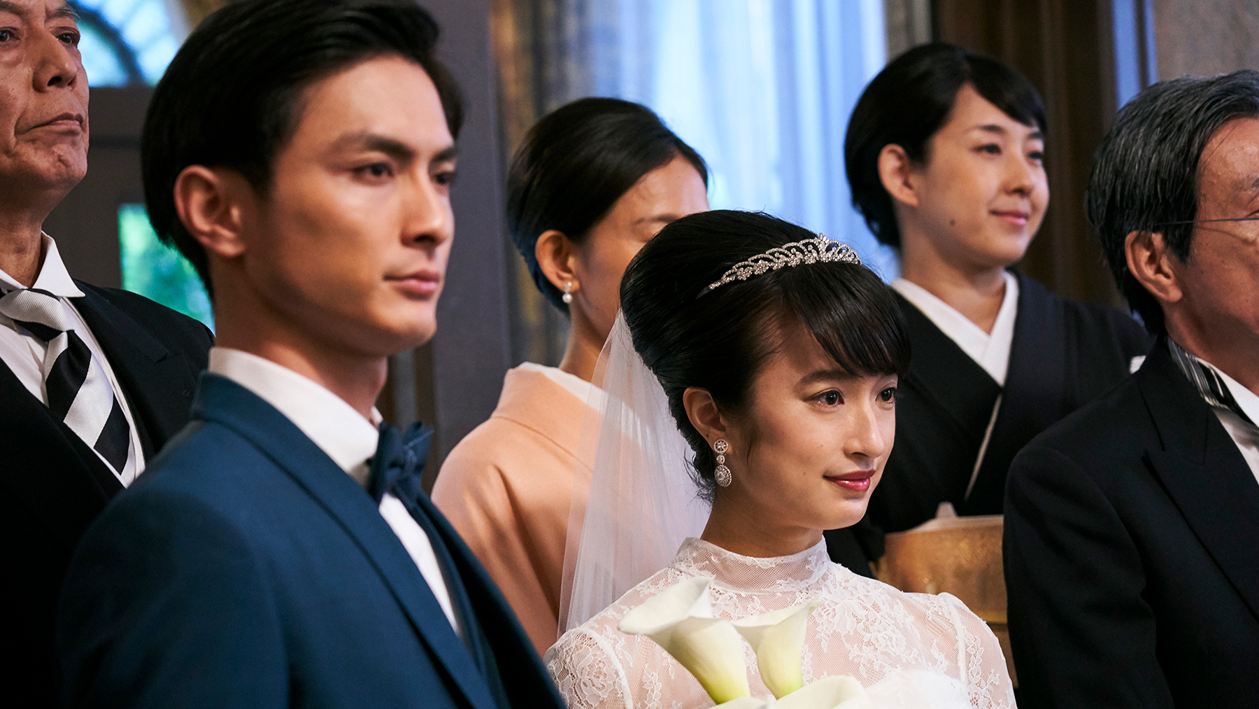 a group of people at a wedding with focus on bride and groom