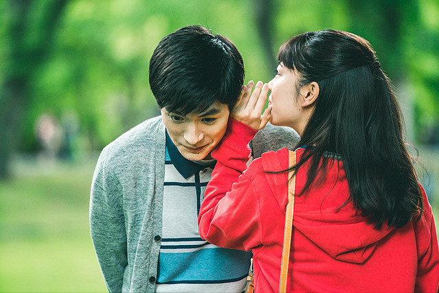 woman telling man a secret