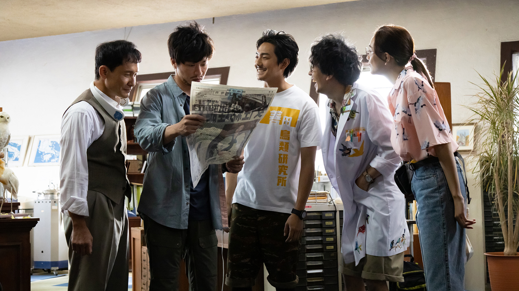 group of people looking at newspaper