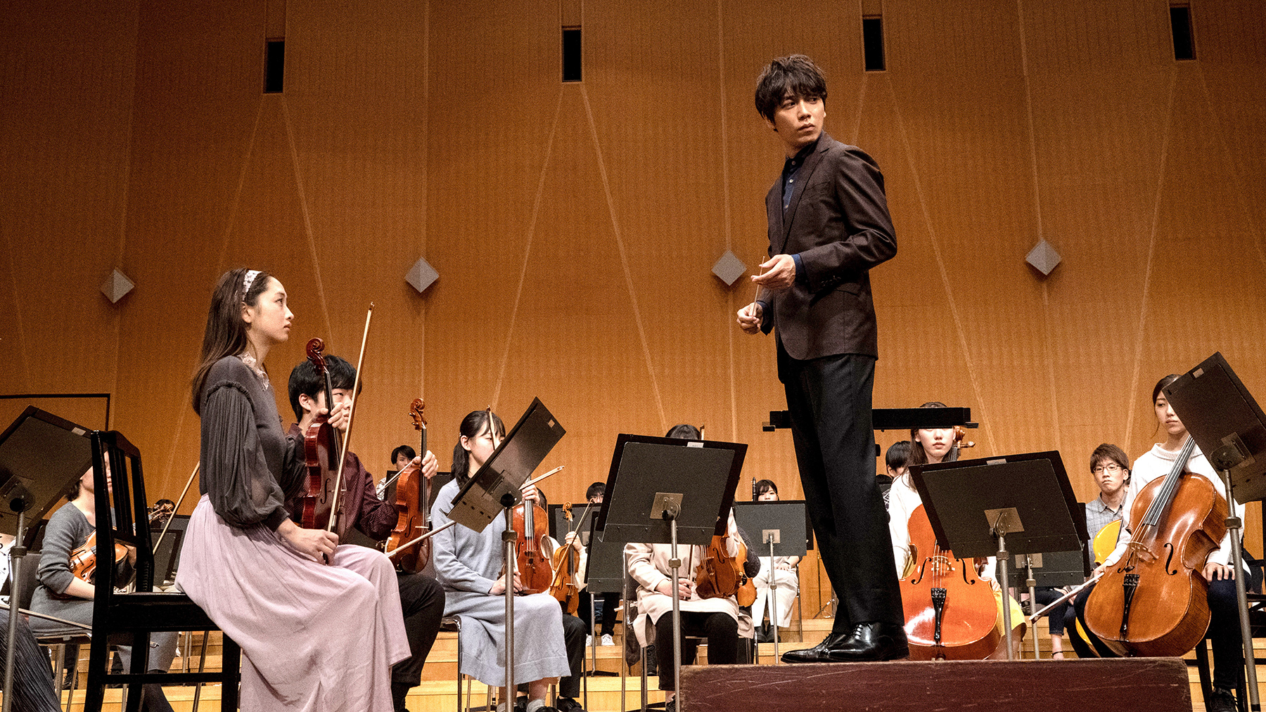man on stage with group of musicians