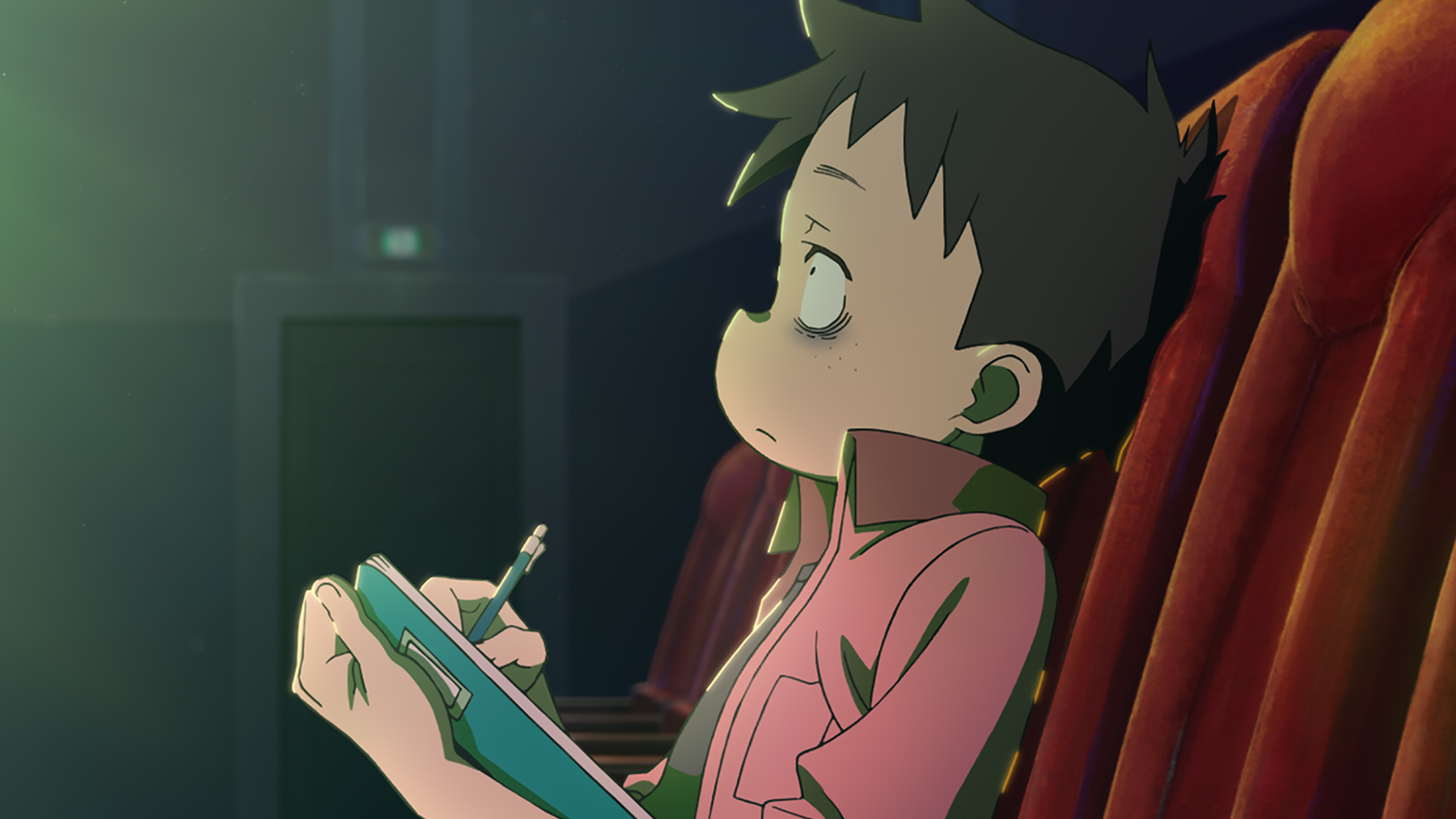 boy taking notes in cinema