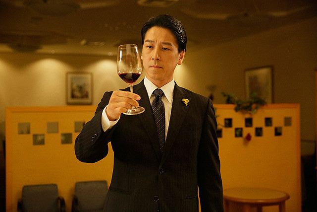 man looking at wine in suit